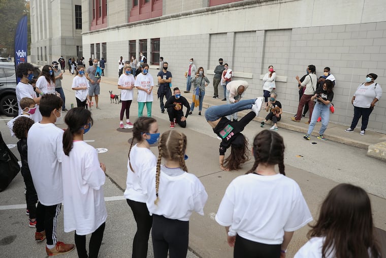 Rachel Snider, an instructor at Movemakers Philly, shows off her moves as the program's students perform for people waiting in line to cast their mail-in ballots at the High School for Creative and Performing Arts in South Philadelphia on Saturday.