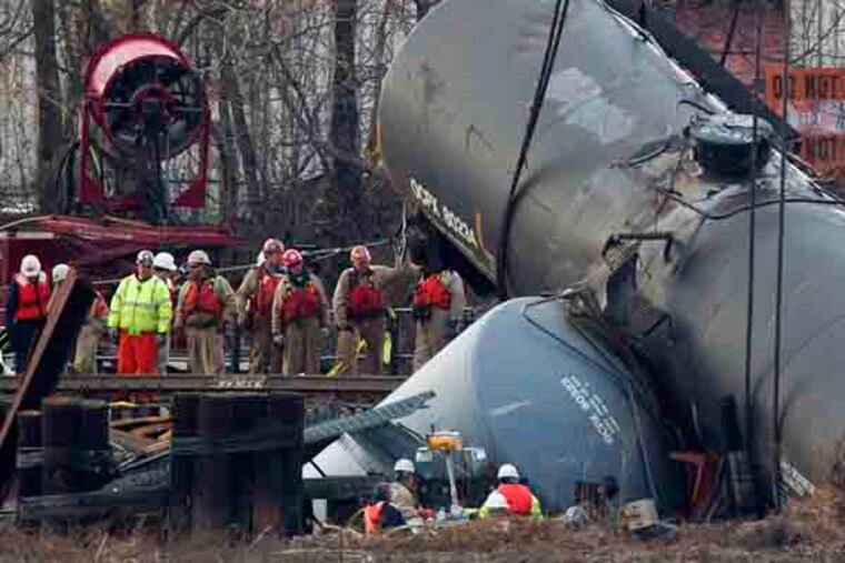 Work crews prepare to hoist the derailed tanker cars from the Mantua Creek in Paulsboro NJ. on the afternoon of Tuesday December 12th. A large crane was brought in to lift the emptied cars. (Ed Hille / Staff Photographer)