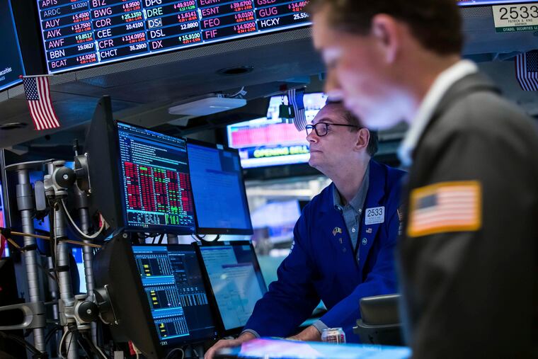 Specialist Patrick King (left) works a his post on the floor of the New York Stock Exchange on Monday.