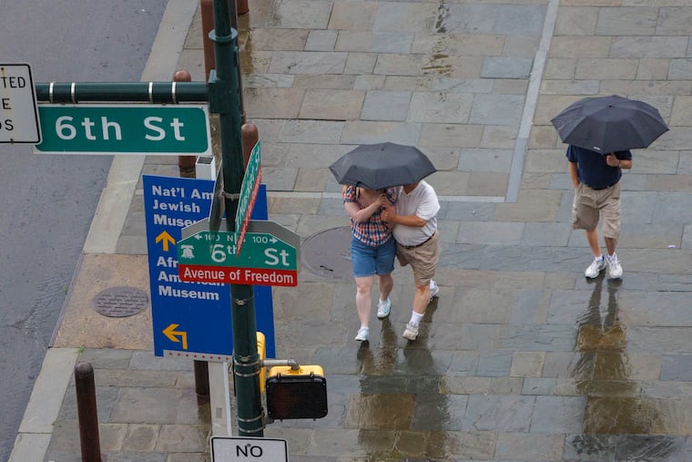Pedestrians walking under umbrellas to shield from the rain falling over Center City Philadelphia. More rain is expected Tuesday afternoon.