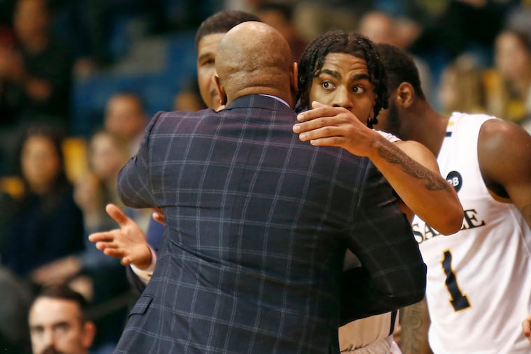 La Salle guard Pookie Powell getting a hug from coach Ashley Howard after leaving the home floor for the last time as an Explorer late in the second half against Fordham on Saturday.