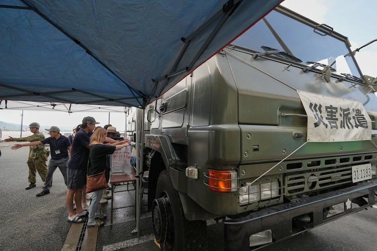 Residents receive a water supply after water service was disrupted following an earthquake in Hikawa, Kumamoto Prefecture, southern Japan, Thursday, July 30, 2026.