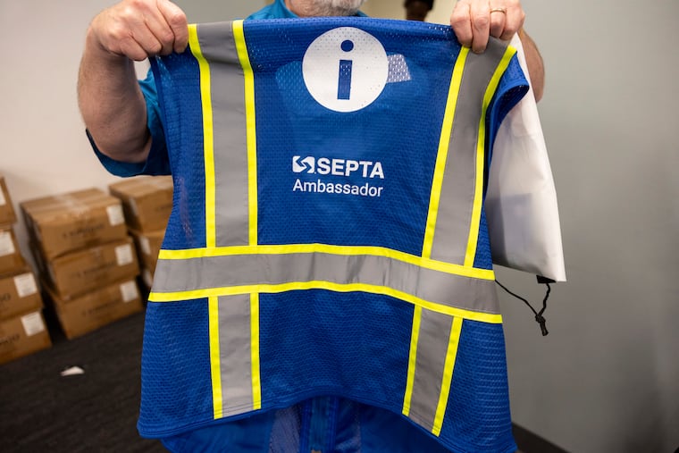 Inquirer Reporter Tom Fitzgerald holds up a SEPTA Ambassador vest before the class.