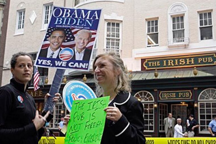 Supporters of Democratic presidential candidate Sen. Barack Obama, D-Ill., Caterina Giordano, left, and Amy Roncace hold signs in front of the Irish Pub in Center City, which Republican vice presidential candidate Alaska Gov. Sarah Palin visited tonight. (AP Photo/Matt Rourke)