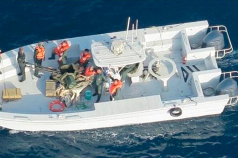 This image released by the U.S. Department of Defense on Monday, June 17, 2019, and taken from a U.S. Navy helicopter, shows what the Navy says is the Islamic Revolutionary Guard Corps Navy after removing an unexploded limpet mine from the M/T Kokuka Courageous. (U.S. Department of Defense via AP)