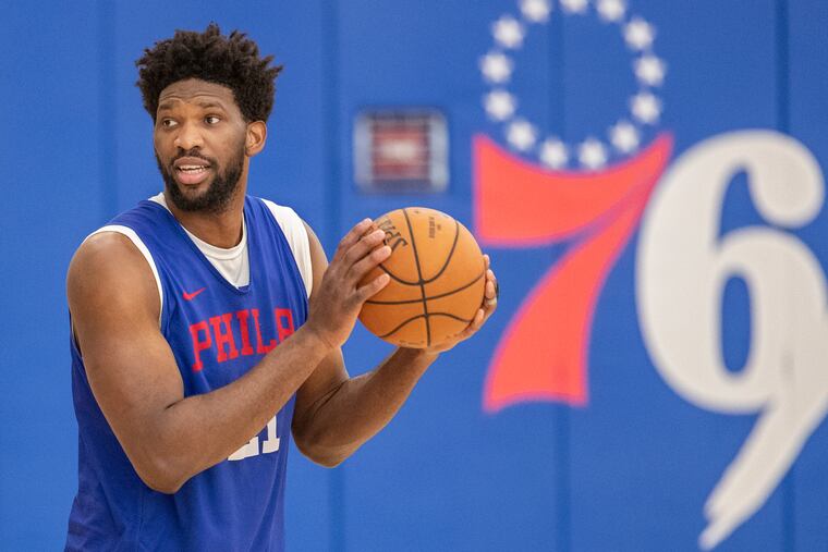 Sixer center Joel Embiid looks to a teammate during shooting drills at practice at the Sixers facility, in Camden, NJ, in February.
