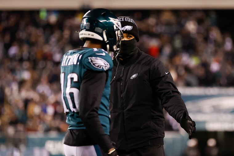 Eagles quarterback Jalen Hurts (right) greeting wide receiver Quez Watkins as Watkins came to the sideline Saturday night against the Cowboys.