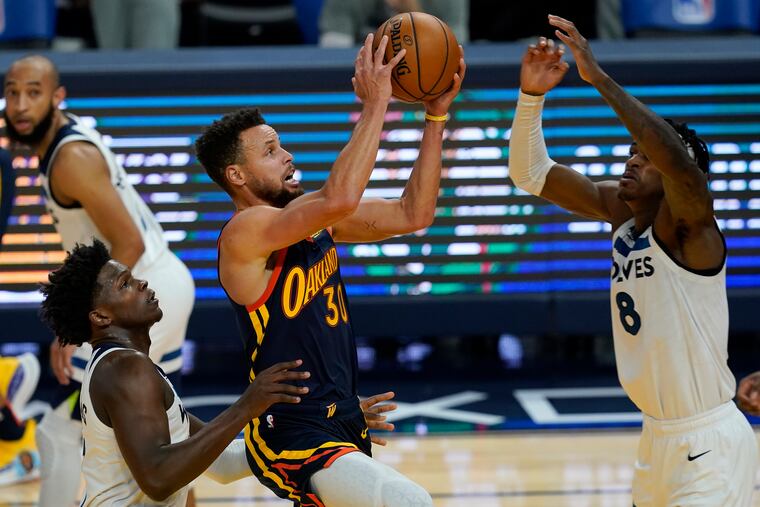 Golden State Warriors guard Stephen Curry shooting between Minnesota Timberwolves guard Anthony Edwards and forward Jarred Vanderbilt (8) on Wednesday. Minnesota has lost eight of its last 10 games.