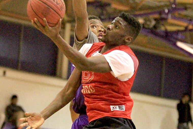 Theo Holloway, right, of Paulsboro goes up for a basket during
a scrimmage against Camden High School. (Charles Fox/Staff
Photographer)