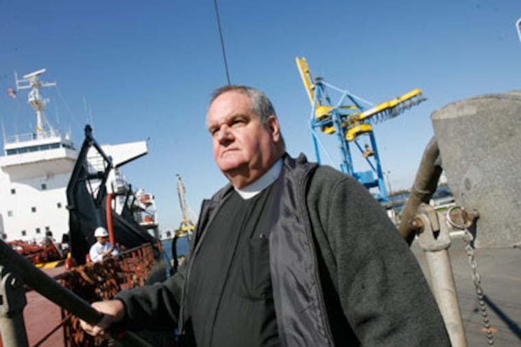 Father James Von Dreele boards the Tos Integrity at the Broadway Marine Terminal on the Camden waterfront. (Charles Fox / Staff Photographer )
