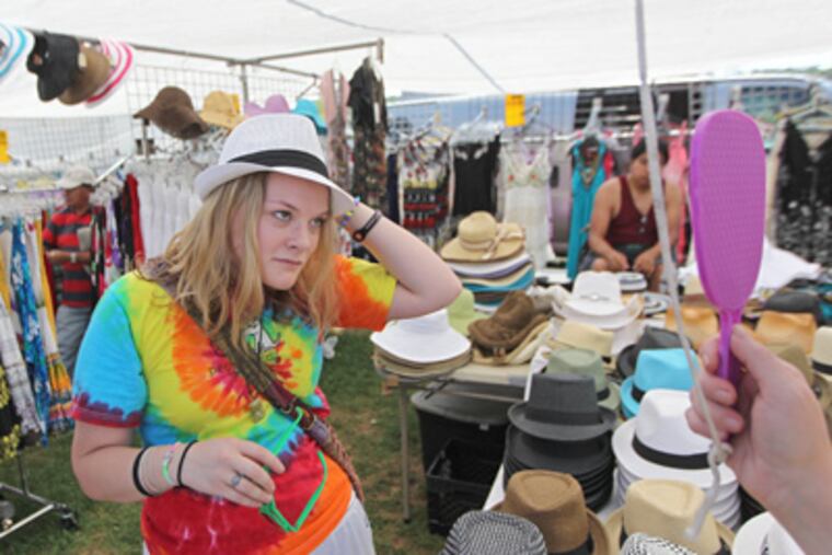 Brittany Leahy tries on a hat as her mother holds a mirror at a booth at the generations-old Rice's Sale & Country Market in Solebury Township. (Michael Bryant / Staff Photographer)