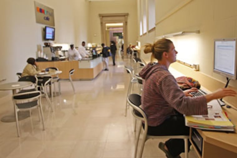 The H.O.M.E. Page cafe was designed perhaps as only a bookmark to remind patrons of what amenities are coming in three to four years in the Moshe Safdie-designed Free Library addition, for which ground is to be broken in December. With the cafe behind her, Meaghan Messner uses the free interrnet access.