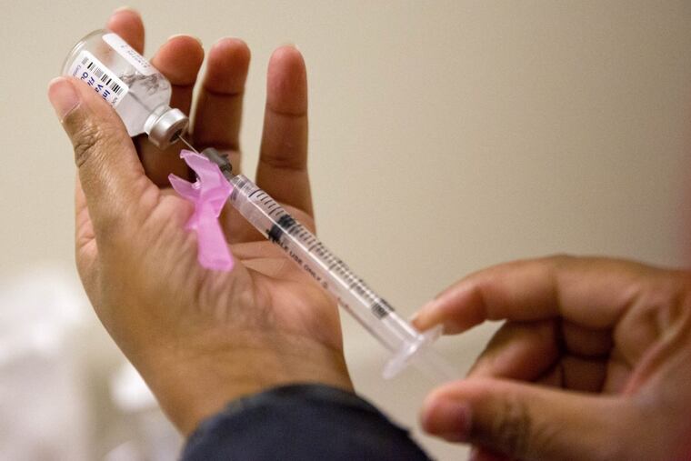 In this Wednesday, Feb. 7, 2018 file photo, a nurse prepares a flu shot at the Salvation Army in Atlanta.