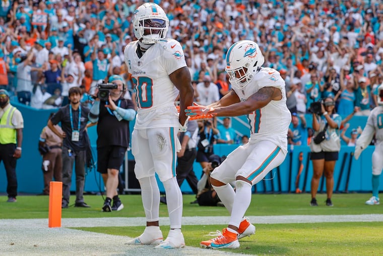 Miami Dolphins wide receiver Tyreek Hill (10) holds his hands behind his back as if he is handcuffed, as teammate Jaylen Waddle pretends to unlock them, after scoring against the Jacksonville Jaguars in the second half on Sunday, Sept. 8, 2024.