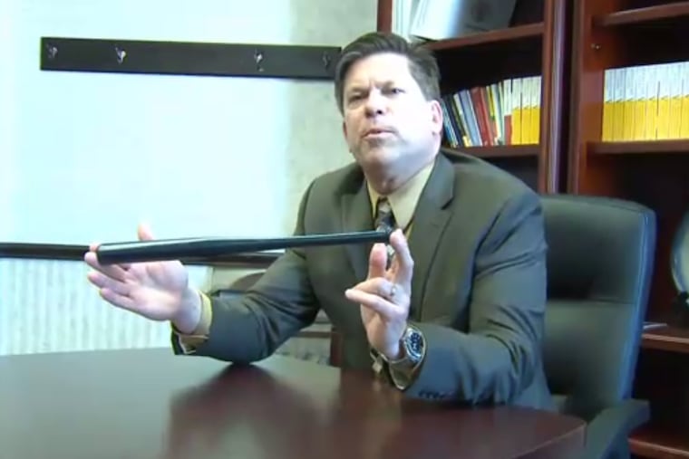 Millcreek Township School District Superintendent William Hall holds one of the bats that teachers received.