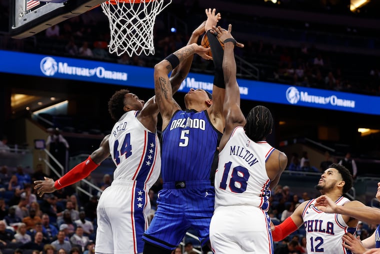 Philadelphia 76ers forward Paul Reed (44) and guard Shake Milton (18) blocks the shot of the Orlando Magic forward Paolo Banchero (5) during the second half of an NBA basketball game Sunday, Nov. 27, 2022, in Orlando, Fla. (AP Photo/Scott Audette)