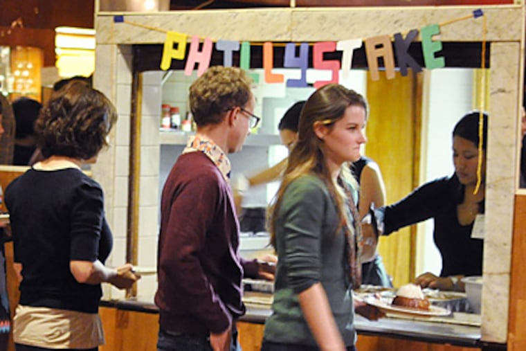 Diners fill their plates at a Stake event at the Ukie Club. Before dessert, they select the groups that will share in the meal’s proceeds. (Gianna Vadino / Staff Photographer)