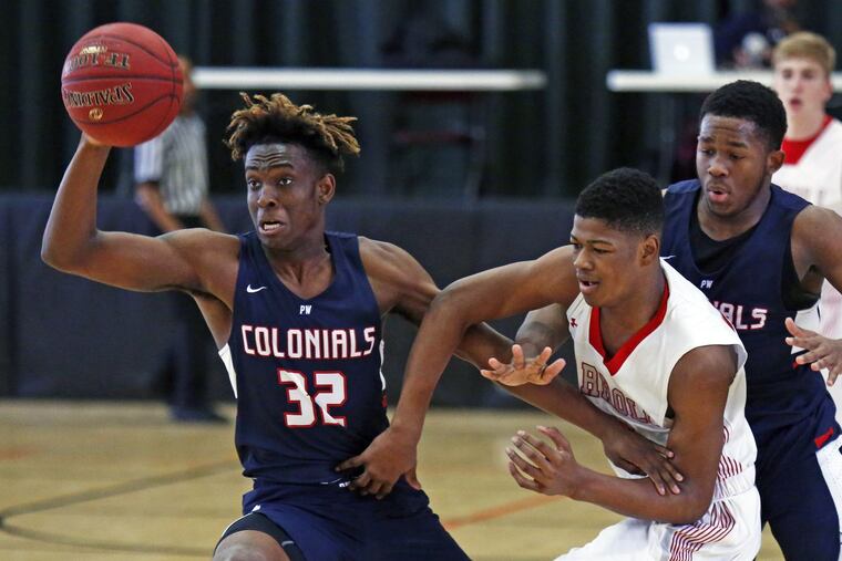 Plymouth Whitemarsh’s Alan Glover (32) beats Archbishop Carroll’s Ny’Mire Little (right) for a loose ball in the Colonials’ 66-53 victory over the Patriots at Archbishop Wood.