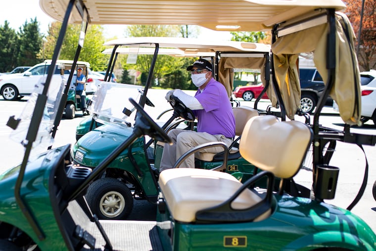 Shawn Quinn, 52, the director of outside operations for the Merchantville Country Club, sterilizes carts and helps get members equipment on Saturday. New Jersey and Pennsylvania have allowed golf courses to reopen this weekend with coronavirus-inspired restrictions.