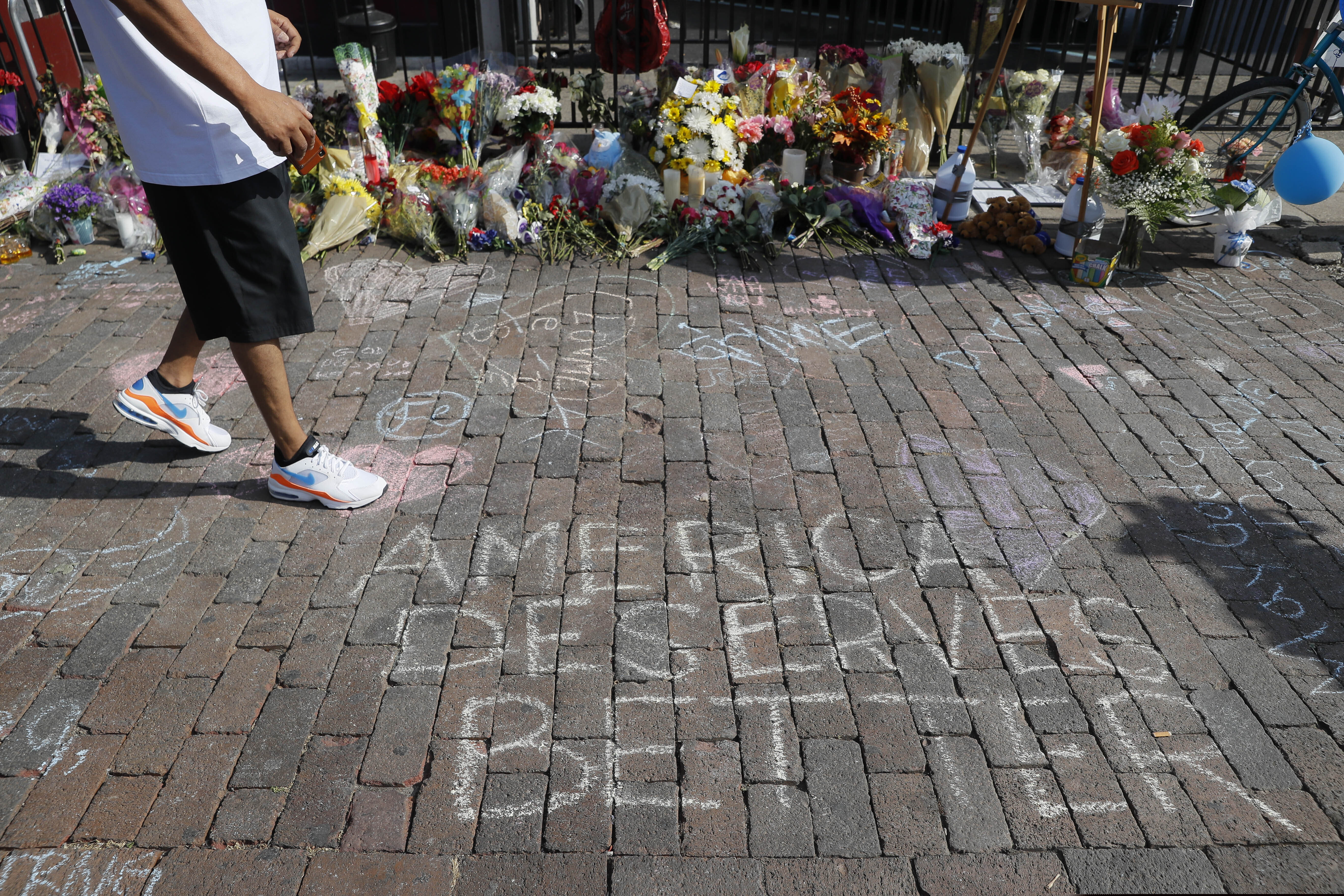 A pedestrian passes a makeshift memorial for the slain and injured victims of a mass shooting that occurred in the Oregon District early Sunday morning, Wednesday, Aug. 7, 2019, in Dayton, Ohio. Twenty-four-year-old Connor Betts opened fire in Dayton early Sunday, killing several people including his sister, before officers fatally shot him.