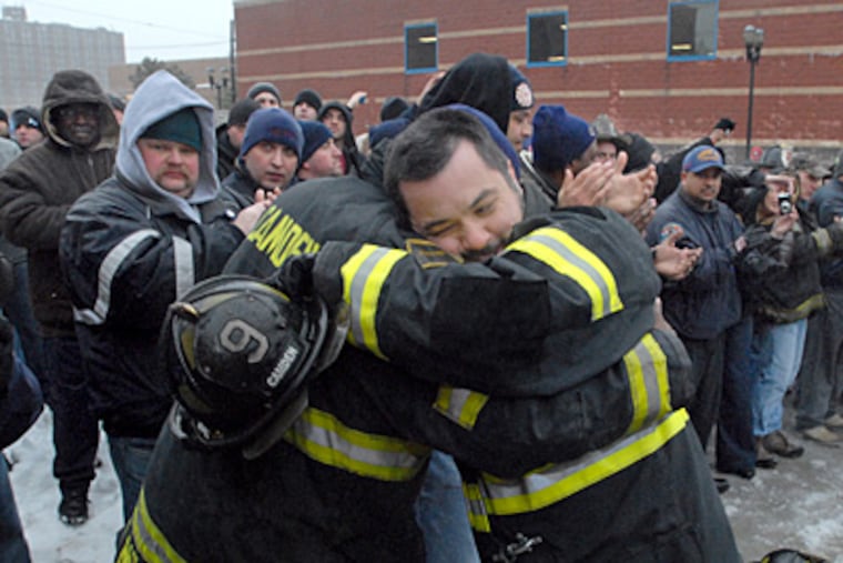Andy Guzman hugged a fellow Camden firefighter when he lost his job Jan. 18. A third of Camden's fire department was laid off because of budget cuts. (April Saul / Staff Photographer)