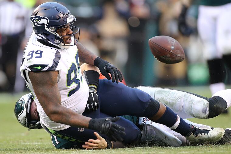 Seahawks defensive tackle Quinton Jefferson falls on Eagles quarterback Carson Wentz's throwing hand as Wentz tries to tackle him after the Eagles fumbled in the third quarter.