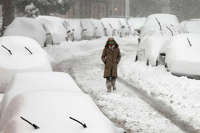 A woman walks down Indian Queen Lane in the city's East Falls section. An official 20.8 inches was measured at Philadelphia International Airport, the sixth-biggest snowfall in 132 years of record-keeping.