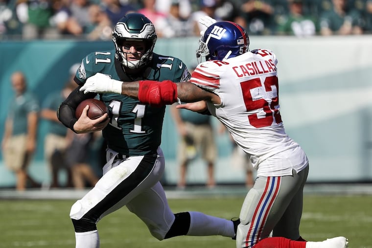 Eagles quarterback Carson Wentz runs with the football as Giants outside linebacker Jonathan Casillas closes in.