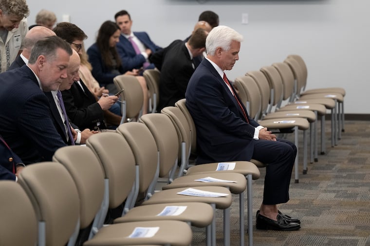 George Norcross III sits in the front row before an announcement by New Jersey Attorney General Matthew J. Platkin charging him on racketeering charges. Norcross was charged Monday with operating a racketeering enterprise, threatening people whose properties he sought to take over, and orchestrating tax incentive legislation to benefit organizations he controlled.