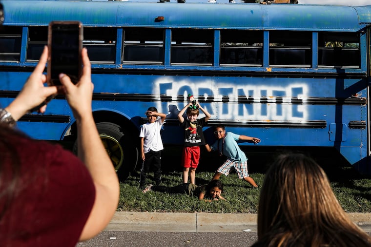 Children pose in front of a school bus made to look like the battle bus from the game "Fortnite" on Dec. 8, 2019, in Indian Rocks Beach, Fla. MUST CREDIT: Photo for The Washington Post by Eve Edelheit