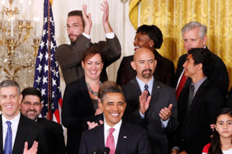 John Becker, a fourth grade teacher from DC Prep Public Charter School in Washington, top row center, reacts after he was acknowledged by President Obama. (AP Photo/Charles Dharapak)