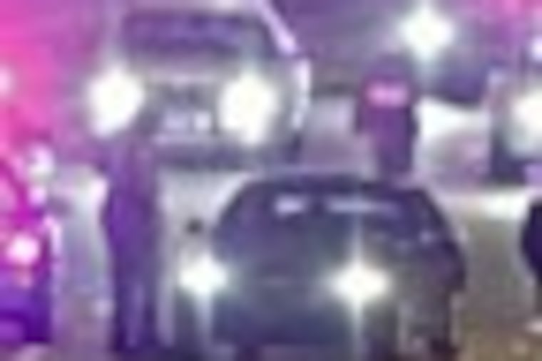 Pennsylvania State Police investigate a fatal shooting of a motorist driving east bound on the Schuykill Expressway in Philadelphia on Sunday April 8, 2012. The victims car is the Buick in the left lane with the driver side door open. (For the Daily News/ Joseph Kaczmarek)