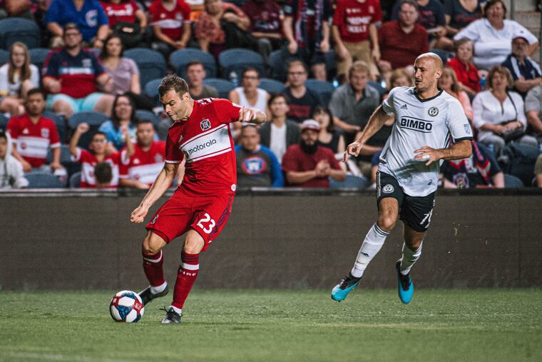Chicago Fire striker Nemanja Nikolic takes a shot during the Fire's 2-0 win over the Union as Union centerback Aurelien Collin runs to catch up.