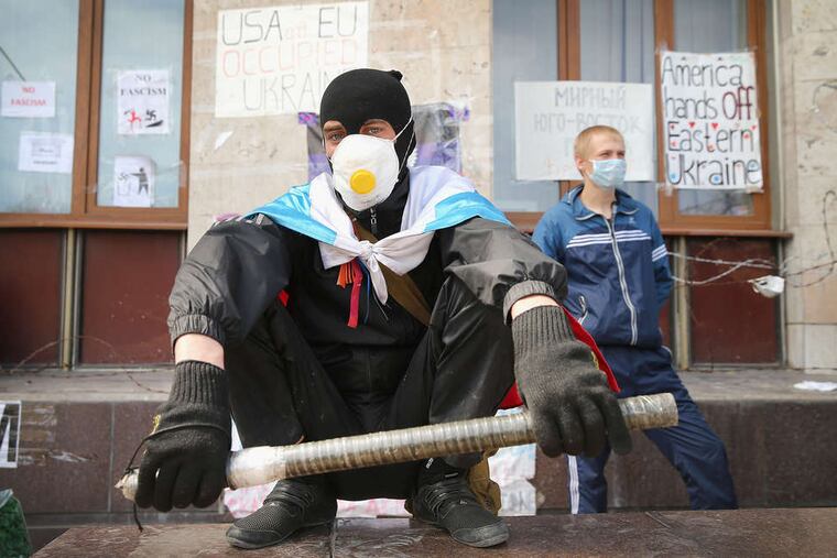 Pro-Russia activists stand guard in front of an administration building in Donetsk, Ukraine. They are refusing to disarm.