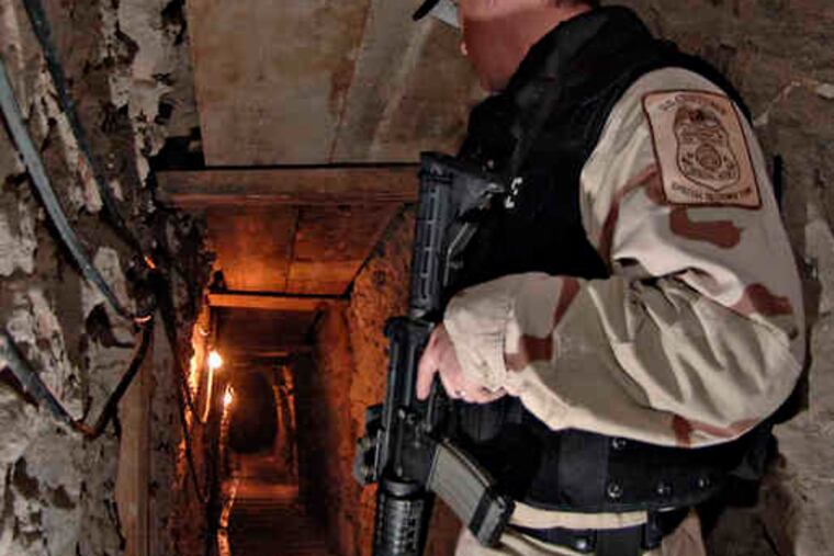 An immigration officer stands guard in San Diego at the U.S. side of a tunnel leading to Mexico used by smugglers.