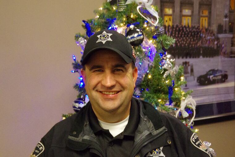 Boise Police Cpl. Kyle Wills holds one of the candy bars his department gives to drivers who commit minor traffic infractions during the holidays. The bars are wrapped in messages about safe driving. Boise PD.