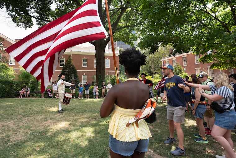 Visitors and historic re-enactors in Signers Park, which features a bronze statue known as "The Signer," dedicated to the Founding Fathers who signed the Declaration of Independence.