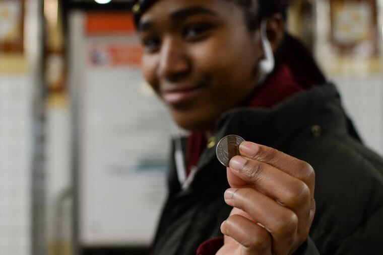 Lailani King, 16, holds up a token at the Spring Garden subway station on the Broad Street Line.
