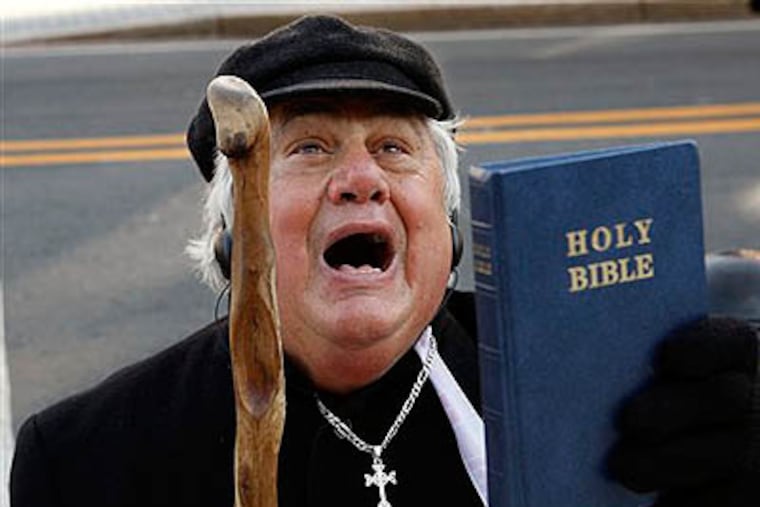 Rev. Martin P. Lombardo, of Princeton, N.J., shouts against gay marriage as he holds a Bible outside the New Jersey Statehouse Thursday. (AP Photo / Mel Evans)
