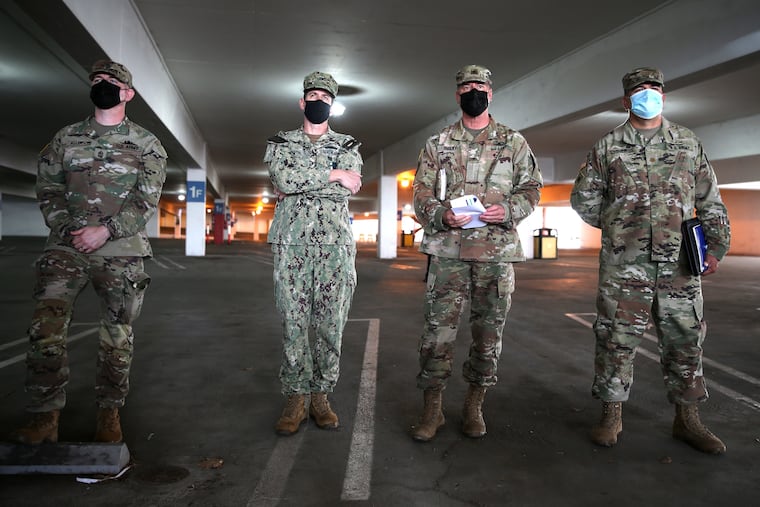 Members of the U.S. military attend a press conference following the opening of a new large scale COVID-19 vaccination site at Cal State Los Angeles on Feb. 16, 2021 in Los Angeles. The vaccine center is staffed by federal and state government workers including members of the National Guard and officials from Federal Emergency Management Agency (FEMA).