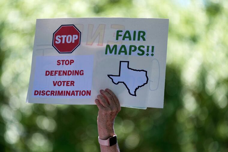 A demonstrator raises a sign during a rally to protest against redistricting hearings at the Texas Capitol in Austin on July 24.