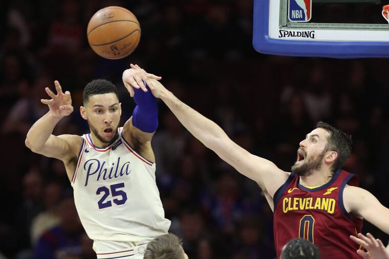 Ben Simmons, left, of the Sixers passes to a teammate after driving the lane while Kevin Love of the Cavaliers defends during the 2nd half at the Wells Fargo Center on April 6, 2018.