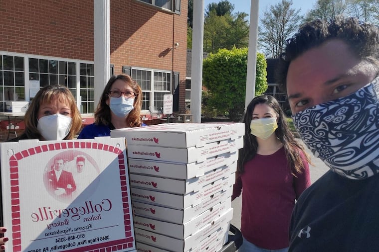 Joe Kekoanui (right) of the Bama Booster Club of Bridgeport delivers pizzas to nurses at Aristacare at Meadow Springs in Plymouth Meeting. The nurses, from left to right, are Donna Winsey Clement, Amanda Baum, and Helena Wagenmann.