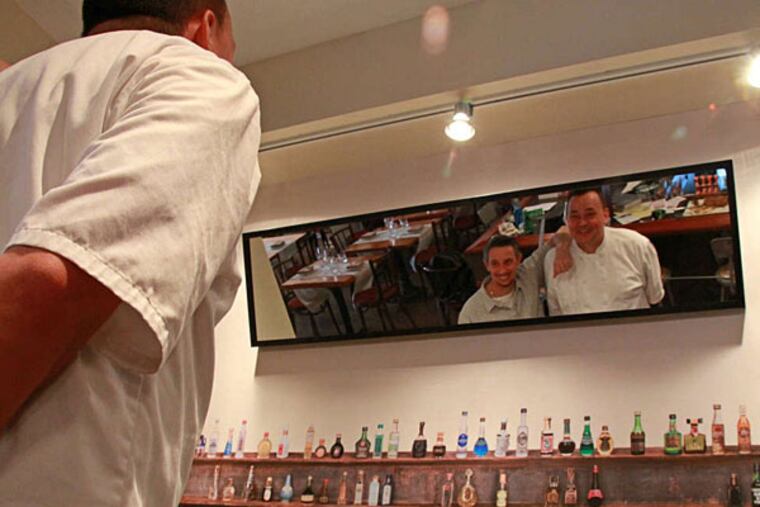 Restaurant Neuf owners Bob Moysan (left) and Joncarl Lachman are reflected in a mirror over a small bar at their South Philadelphia restaurant. ( Michael Klein / Philly.com )