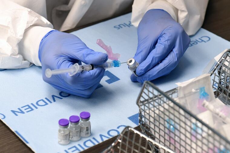 Student pharmacist Wilbur Quimba dilutes vials of the Pfizer-BioNTech COVID-19 vaccine at University Medical Center of Southern Nevada in Las Vegas on Wednesday.