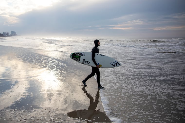 Cassidy McClain, 24, of Ventnor City, N.J., rushes out toward the ocean at Ventnor City Beach on Saturday. Due to the coronavirus pandemic, McClain has been kept off the water for 45 straight days.