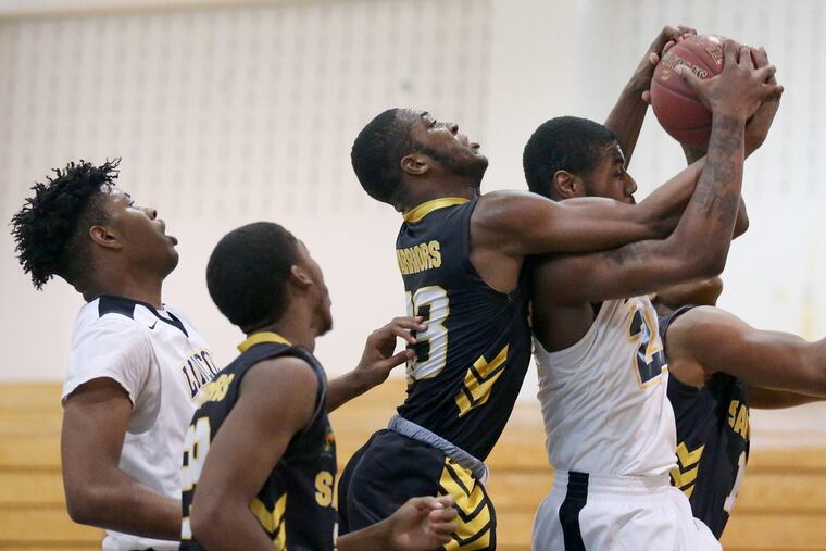 Sankofa’ Scott Spann (23) wrestles for a rebound with Lincoln’s Jahi Randall (23) during a game in January.