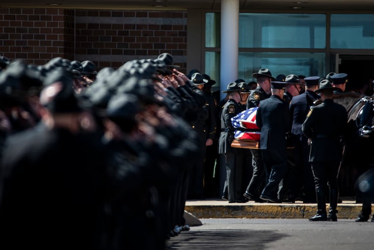 Pallbearers remove the casket from Trappe Fire Company's Engine 77 and carry it inside Perkiomen Valley High School in Collegeville Saturday for the funeral service for State Trooper Branden T. Sisca.
