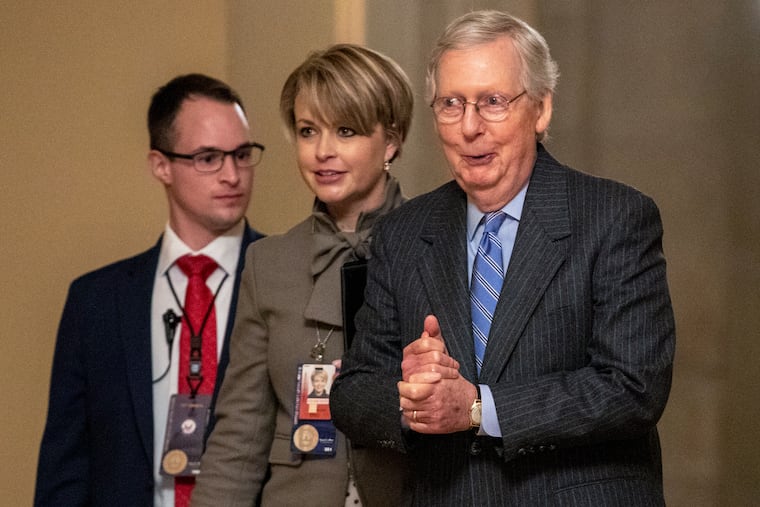 Senate Majority Leader Mitch McConnell (right) walks to meet with Senate Republicans after the Senate voted Friday to not allow witnesses in the impeachment trial of President Donald Trump.