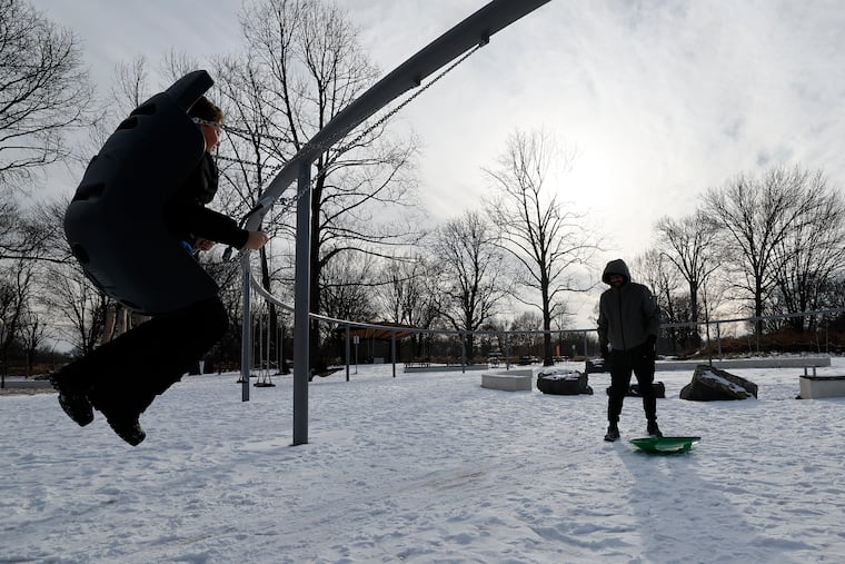 A child swings at a South Philadelphia park during a January 2025 snowstorm.